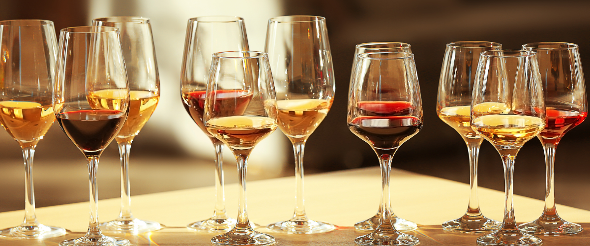 a series of different wine glasses with different wines in each on a table
