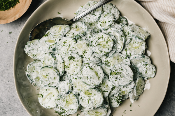 Overhead view of creamy cucumber salad in a ceramic bowl