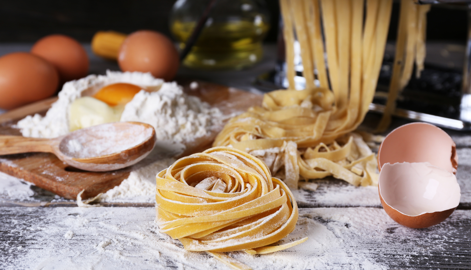 Close up of a pasta work bench filled with flour, eggs, shells, finished pasta
